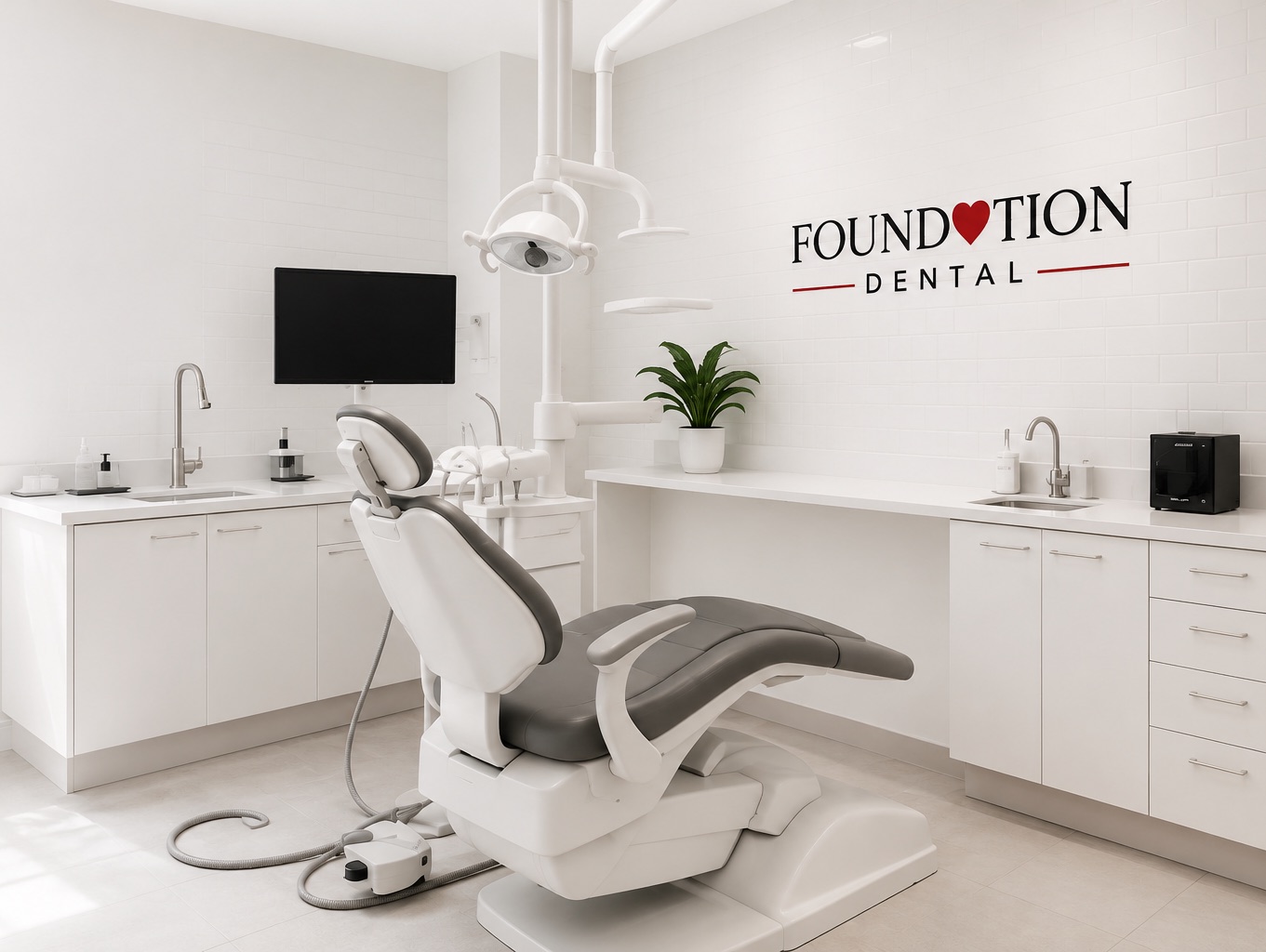 Bright, modern dental operatory with a white treatment chair, clean cabinetry, and the Foundation Dental logo on the wall